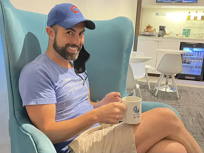 Two Gay Expats - Huatulco Airport, Oaxaca, Mexico - Lounge - Trai Enjoying Coffee