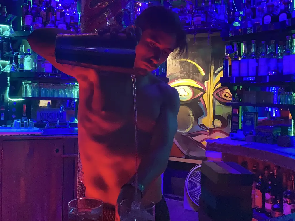 Chizme Gay Bar - Sexy bartender pouring a drink
